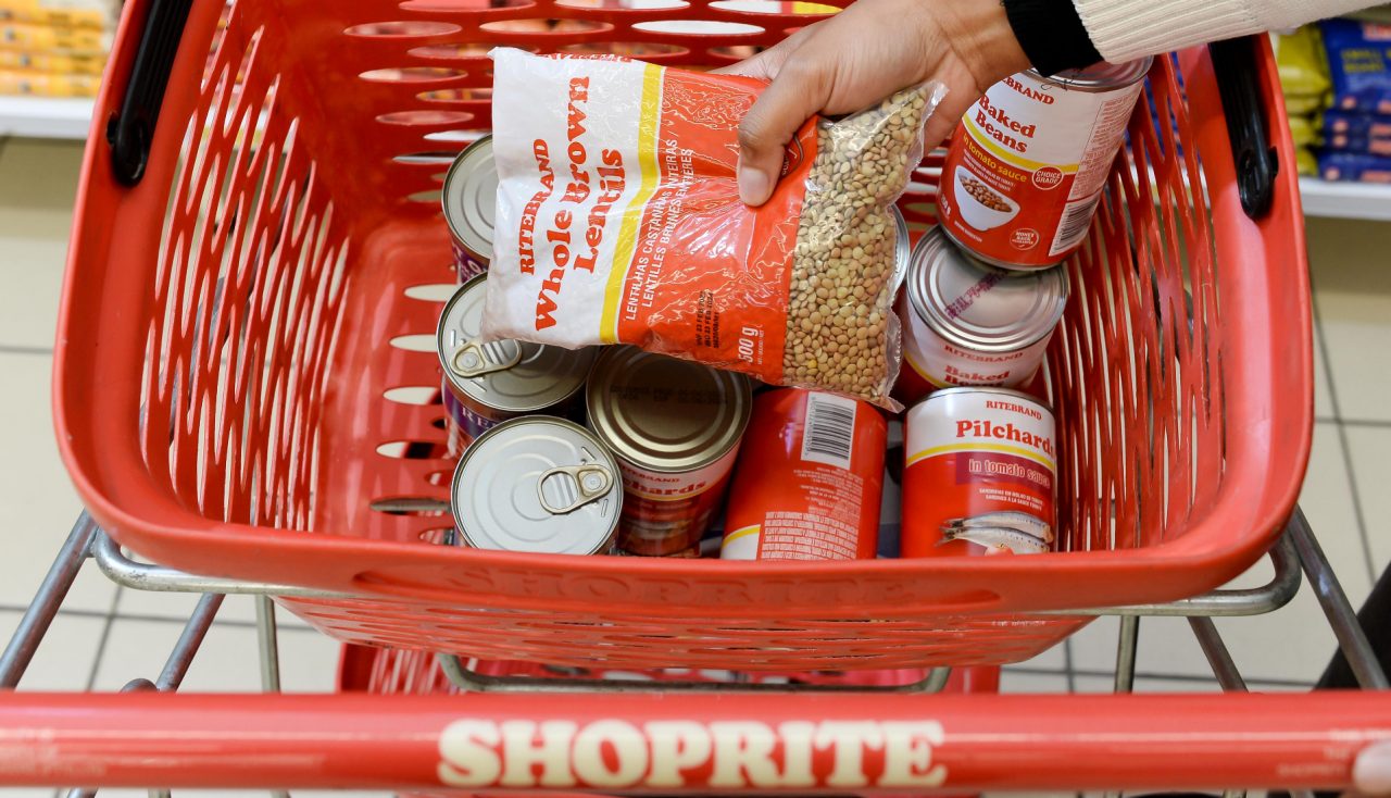 A Shoprite basket full of canned food.