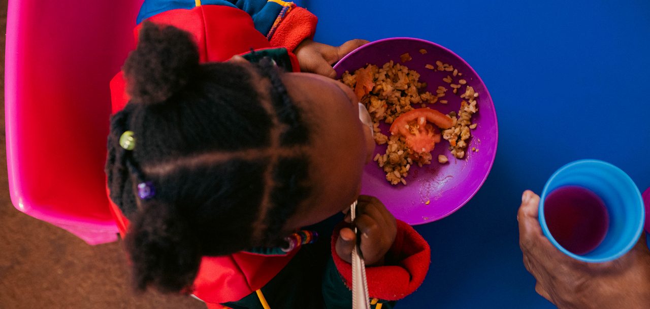 A pre-school kid eating a meal.