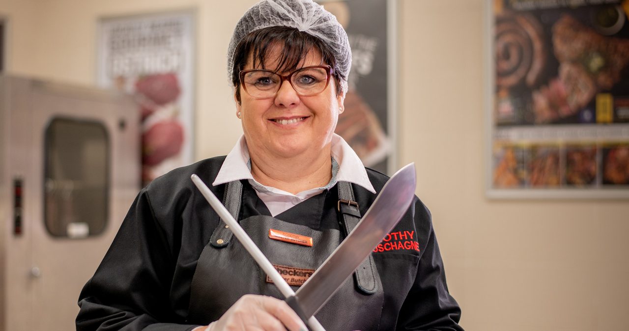 A woman with a hairnet sharpening her knife.